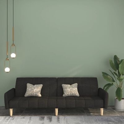 Sofá cinza escuro com almofadas geométricas e iluminação pendente dourada