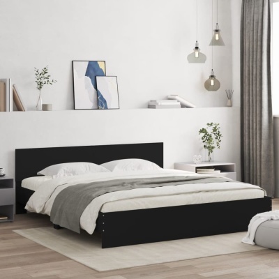 Quarto minimalista com cama preta, roupa de cama branca e cinza, mesas de cabeceira, plantas e candeeiros suspensos.