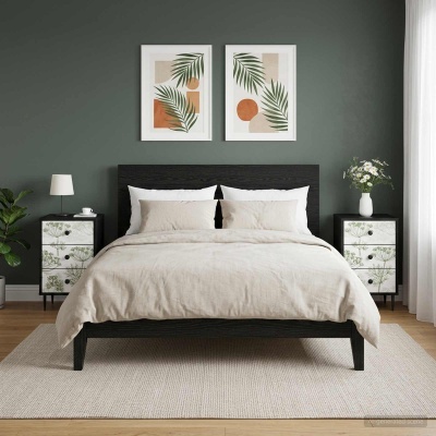 Quarto com cama madeira negra, roupa de cama bege, mesas de cabeceira pretas com padrão floral, jarra com flores e abajur branco