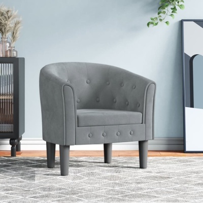 Poltrona cinzenta com botões decorativos, pernas cilíndricas e tapete geométrico cinzento