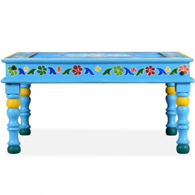 Mesa baixa azul com decoração floral colorida e pernas torneadas.