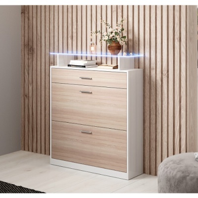 Móvel de arrumação branco com gavetas em madeira clara e objetos decorativos no topo