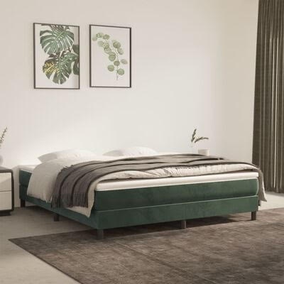 Cama verde escuro com roupa de cama branca e cobertores cinzentos num quarto minimalista