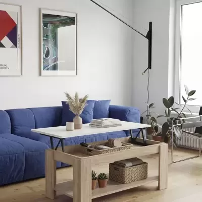 Mesa de centro extensível em sala com sofá azul e candeeiro de parede