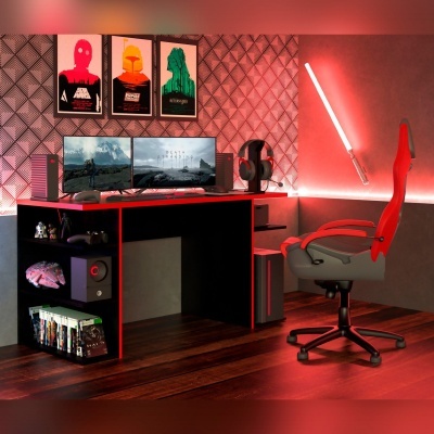 Setup gaming com secretária preta, dois monitores, cadeirão cinza e vermelho, sabre de luz na parede e posters.