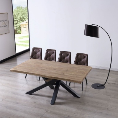 Mesa de jantar com tampo de madeira clara, base preta em X, quatro cadeiras de couro castanho e lâmpada de pé preta