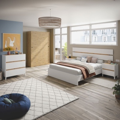 Quarto moderno com móveis brancos, cama de casal, armário de madeira clara, tapete bege geométrico e pufe azul.