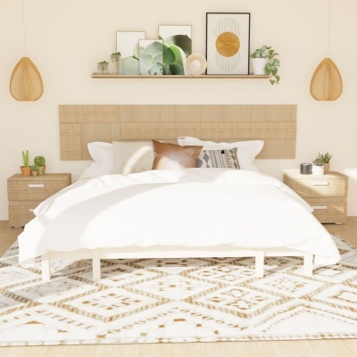 Quarto com cama de madeira, colcha branca, almofadas, mesas de cabeceira, candeeiros pendentes, prateleira com quadros e tapete geométrico.