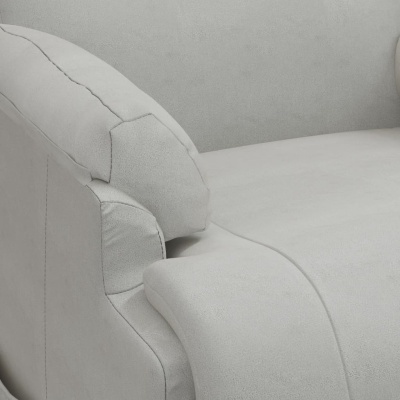 Sofá cinza claro com almofada solta e costuras detalhadas