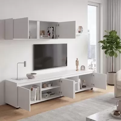 Móvel de TV branco com portas abertas e televisão montada na parede numa sala moderna com planta e candeeiro