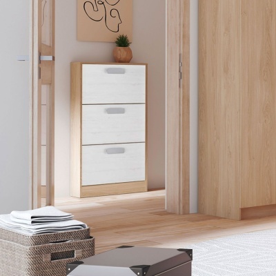 Móvel de arrumação para sapatos em madeira clara com portas brancas e puxadores cinza, num corredor com chão em madeira