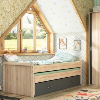 Cama de madeira clara com gavetas cinza numa esquina de quarto infantil decorado com padrões de estrelas e zig-zag nas paredes e duas ilustrações infantis em molduras.