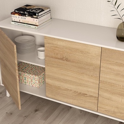 Móvel com portas de madeira claras e decoração sobre ele