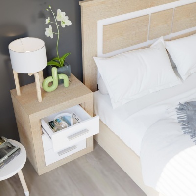 Mesa de cabeceira em madeira clara com candeeiro branco e vaso com orquídeas ao lado de cama com roupa branca e cabeceira de madeira