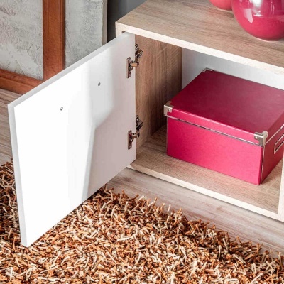 Armário de madeira clara com porta branca aberta e caixa vermelha no interior