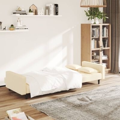 Cama de solteiro estofada creme com edredão branco numa sala com estante de madeira e prateleiras brancas