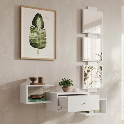 Móvel de parede branco com gaveta aberta e plantas decorativas, quadros de folhas verdes na parede bege