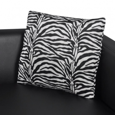 Almofada com padrão de zebra preta e branca sobre sofá preto