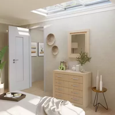 Quarto com cómoda de madeira clara e decoração minimalista sob luz natural