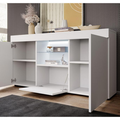 Móvel de sala branco com prateleiras abertas e portas, decorado com livros e vasos, em ambiente interior com chão de madeira.