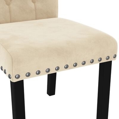 Cadeira estofada bege com pernas pretas e tachas metálicas