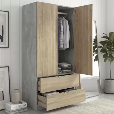Roupeiro cinzento e madeira clara aberto com roupa pendurada e gavetas abertas em ambiente moderno com planta e espelho