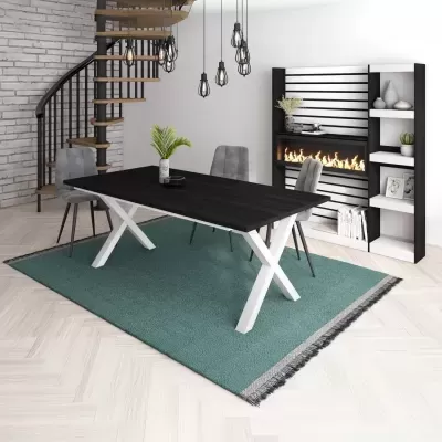 Mesa de jantar preta com pernas brancas em X com cadeiras cinza, tapete verde, escada em espiral e estante com lareira