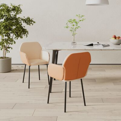 Duas cadeiras cor de ferrugem claro com pernas pretas num ambiente interior minimalista com mesa branca e planta