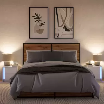 Quarto com cama de casal de madeira e metal, roupa de cama cinza, mesas de cabeceira brancas iluminadas, abajures e quadros abstratos