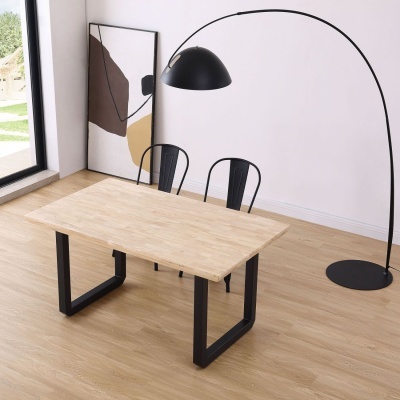 Mesa de madeira clara com cadeiras pretas e candeeiro de pé negro em ambiente interior