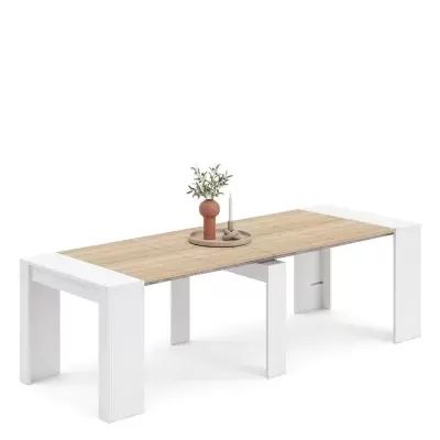 Mesa extensível com tampo em madeira clara e estrutura branca decorada com vaso e castiçal