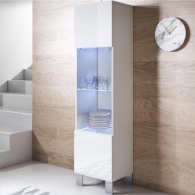 Móvel alto branco de vidro com iluminação interior e pratos copos, junto a parede de madeira e escadas.