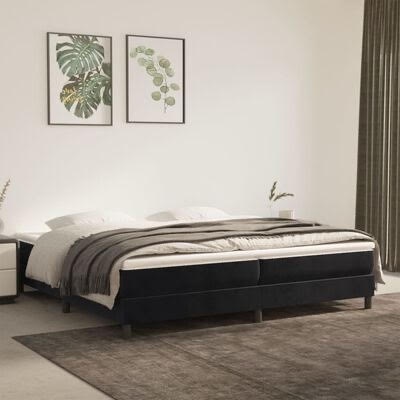 Cama de casal estofada preta com roupa branca e cinzenta em quarto moderno com decoração de folhas verdes