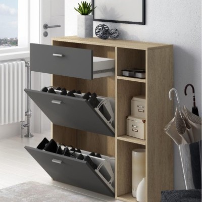 Móvel de arrumação em madeira clara com portas cinza escuro e decoração com planta e quadro