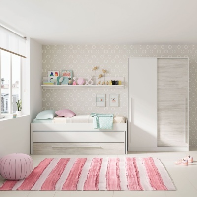 quarto infantil com cama branca, almofadas coloridas e tapete rosa