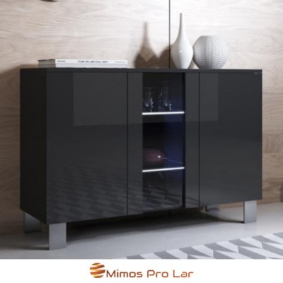 Móvel preto lacado com portas, vidro central, copos, garrafas, vasos brancos e livro em cima, parede madeira clara