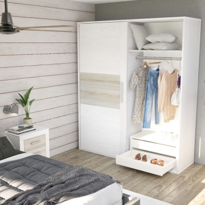 Roupeiro branco com porta deslizante, roupas penduradas e gavetas abertas numa divisão com parede de madeira branca, cama e mesinha de cabeceira.