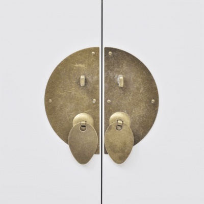 Fecho de porta duplo redondo em metal envelhecido numa porta branca