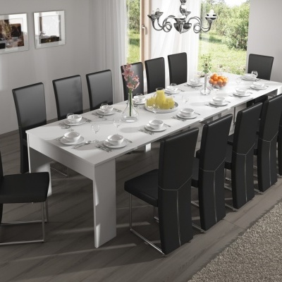 Mesa de jantar branca com 12 cadeiras pretas e utensílios de jantar brancos num ambiente com janela e decoração