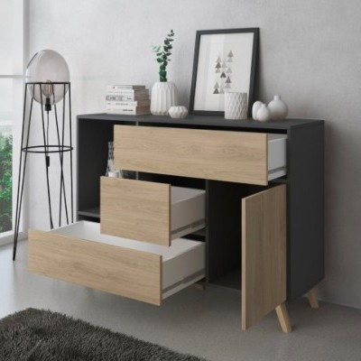 Cómoda preta com gavetas e porta de madeira clara, decoração em cima e candeeiro ao lado