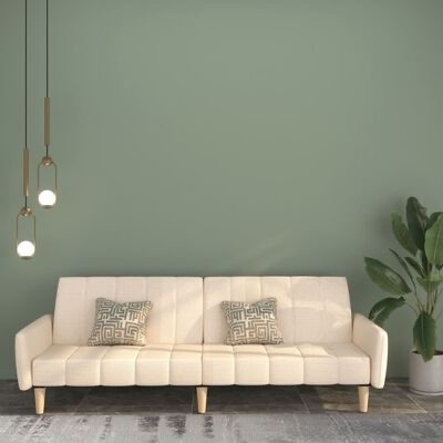 Sofá bege com almofadas cinzentas e pendentes dourados em sala com parede verde e planta