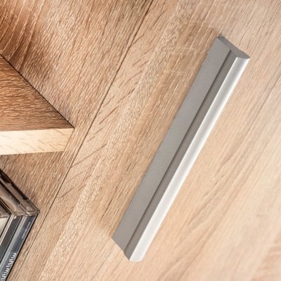 Puxador cinzento claro numa superfície de madeira clara com padrões naturais