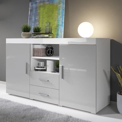 Aparador branco com portas cinza brilhante, decoração com livros, relógio, plantas e candeeiro redondo branco