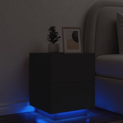 Mesa de cabeceira preta com luz azul, vaso com planta e moldura decorativa