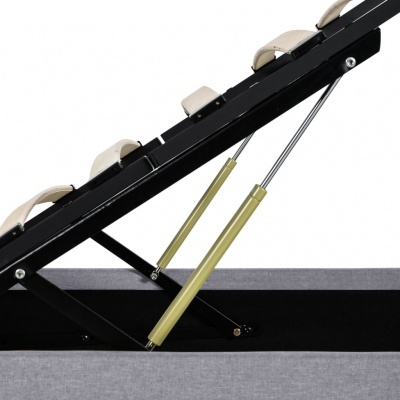 Banco ou baú de arrumação cinzento com tampa preta acolchoada e pistões hidráulicos dourados