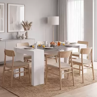 Mesa de jantar branca com seis cadeiras de madeira clara e estofado bege numa sala clara