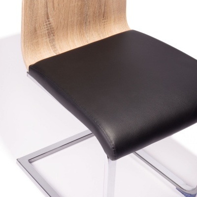 Cadeira com assento preto em couro e encosto em madeira clara
