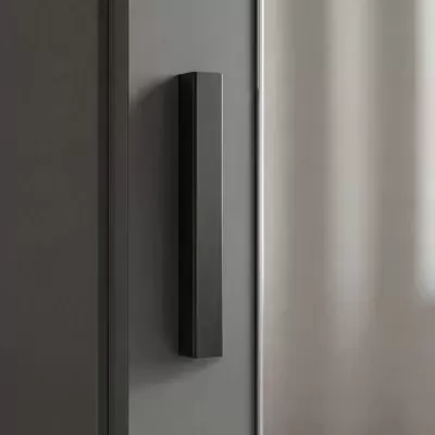 Puxador de porta metálico preto fosco numa porta cinza