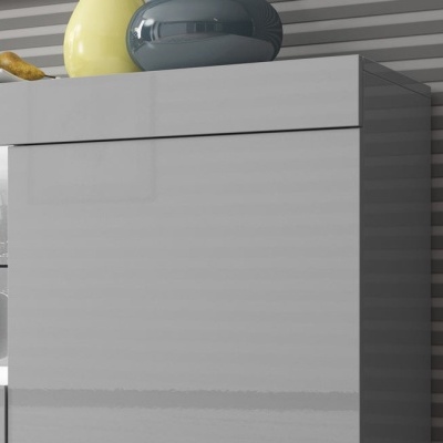 Móvel cinza claro com acabamento brilhante e peças decorativas cerâmicas amarelas e cinza escuro.