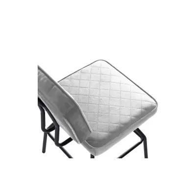 Cadeira estofada cinza com padrão acolchoado e estrutura metálica preta